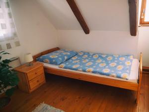 a bedroom with a bed with a blue comforter at Zelená chalúpka in Spišská Nová Ves
