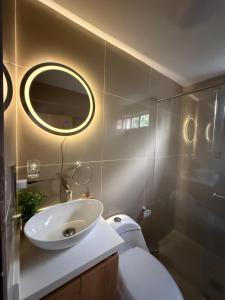 a bathroom with a sink and a toilet and a mirror at Habitaciones Stonehaven Ruitoque in Piedecuesta +86 photos
