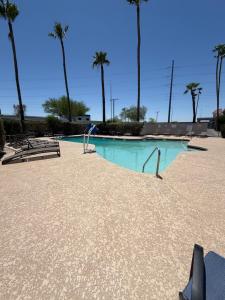 a swimming pool with chairs and palm trees at Extend-a-Suites Phoenix in Phoenix