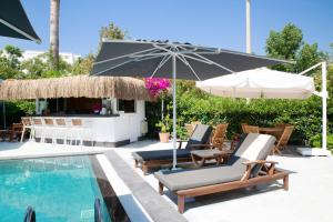 a pool with lounge chairs and an umbrella and a bar at Sör Apart Otel in Bodrum City