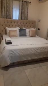 a large bed with a large headboard and pillows at Hayorttas Apartment in Cardoso
