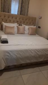 a large white bed with a large headboard and pillows at Hayorttas Apartment in Cardoso +10 photos
