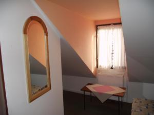 a room with a mirror and a table and a window at Penzión Slávia in Poprad