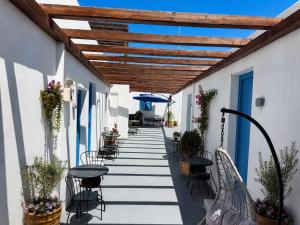 a walkway with chairs and tables and an umbrella at ELEVEN KEYS APARTMENTS in Vrisi/ Mykonos