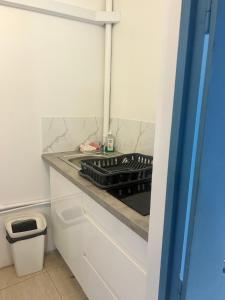 a kitchen with a stove top oven next to a trash can at studio Sainte Anne 2mn a pieds de la plage in Sainte-Anne +10 photos