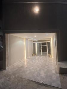 an empty room with a white wall and a tile floor at الشروق in Al Baha