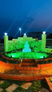 a fountain with green lighting in a park at night at Snehdeep Villa, Konkan Trail in Dapoli +6 photos