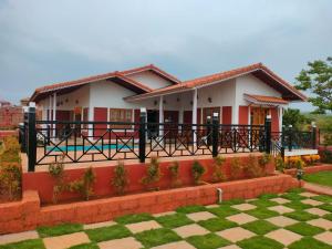 a house with a fence in front of it at Snehdeep Villa, Konkan Trail in Dapoli