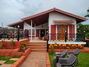 a house with chairs in front of it at Snehdeep Villa, Konkan Trail in Dapoli