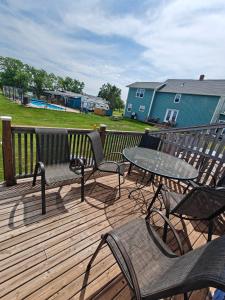 a deck with chairs and a table and a table and chairs at Dreamweavers Cottages and Vacation Homes in Rustico