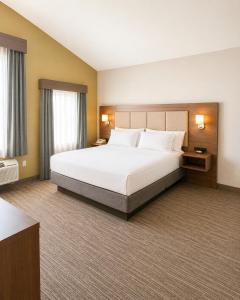 a hotel room with a large bed and two windows at Holiday Inn Express Durham-UNH by IHG in Durham