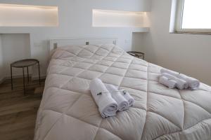 a white bed with towels on top of it at Corte EDN7 in Sannicandro di Bari