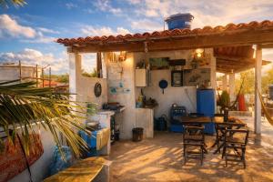 a kitchen with chairs and a table and a counter at Trip Hostel e Pousada in Jericoacoara