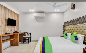 una camera da letto con un letto, una scrivania e una televisione di Palash hotel a Dānāpur