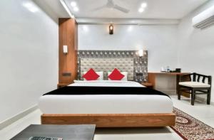 una camera da letto con un grande letto con cuscini rossi di Palash hotel a Dānāpur