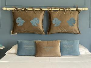 a bed with three pillows with butterfly cushions at Villa Antonietta Ischia in Forio d'Ischia