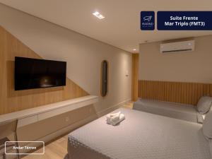 a hotel room with a bed and a flat screen tv at Marino Beach Hotel in Cabo Frio