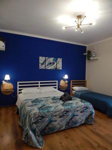 a bedroom with a bed with a blue wall at Suli e Sali Apartment in Calatabiano +9 photos