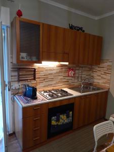 a kitchen with wooden cabinets and a stove top oven at Suli e Sali Apartment in Calatabiano