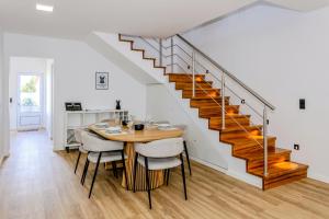 a dining room with a table and a staircase at The Frenchie's House in Rabo de Peixe