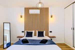 a bedroom with a king sized bed with a striped wall at The Frenchie's House in Rabo de Peixe
