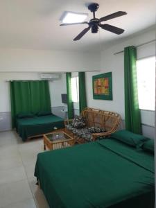 a green bedroom with two beds and a ceiling fan at Apartamento Finca Verde in Las Carreras