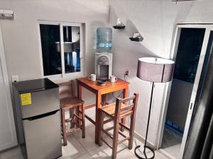 a small kitchen with a small table and a refrigerator at La Isla Studio - Quimixto in Qumiste