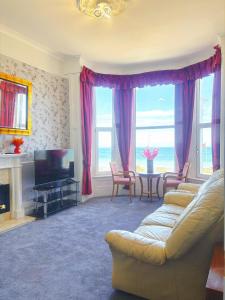 a living room with a couch and a television at Downshire House in Douglas