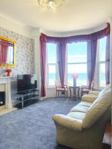 a living room with a couch and a television at Downshire House in Douglas +62 photos