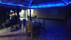 a patio with a table and chairs under a blue light at Apartamento Finca Verde in Las Carreras