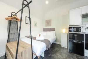 a small room with a bed and a kitchen at The Snug - Cosy Annexe Hideaway in Portishead