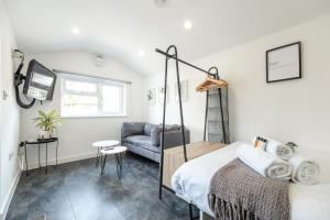 a bedroom with a bed and a couch at The Snug - Cosy Annexe Hideaway in Portishead