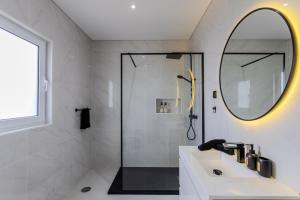 a bathroom with a sink and a shower with a mirror at The Frenchie's House in Rabo de Peixe +30 photos