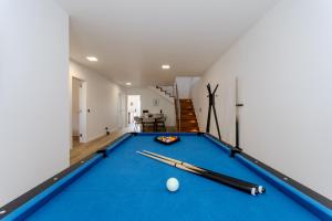 a pool table with two cuesticks on top of it at The Frenchie's House in Rabo de Peixe