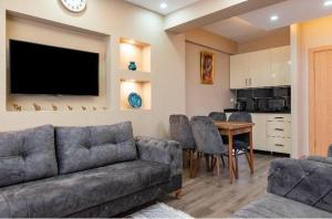 a living room with a couch and a table with chairs at Saltanat Apartment in Istanbul