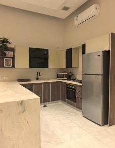 a kitchen with a stainless steel refrigerator and cabinets at دره العروس الشاطي in Jeddah