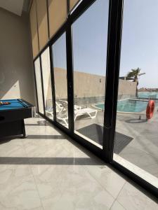 a room with a pool table and a sliding glass door at دره العروس الشاطي in Jeddah