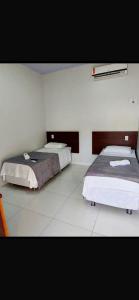 a room with two beds in a room at Hotel Mirage in Alta Floresta