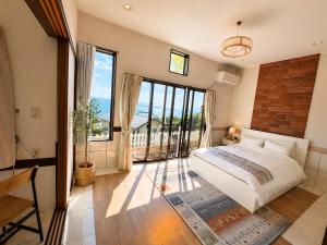 a bedroom with a large bed and a large window at Villa Amoria Ocean View in Miyazaki +25 photos