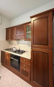 a kitchen with wooden cabinets and a stove top oven at Casa Lanterna - Sottomarina in Chioggia +37 photos
