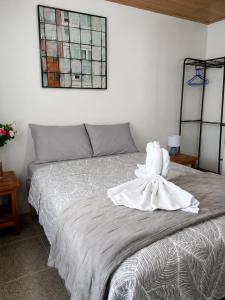a bedroom with a bed with a towel on it at Arenal Rental CASA PALMERA UNO in Arenal
