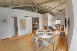 a dining room and living room with a table and chairs at Kantouni Corfu in Potamós