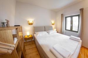 a bedroom with a bed with white sheets and a window at Kantouni Corfu in Potamós