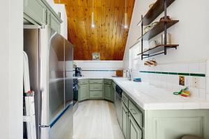 a kitchen with green cabinets and a refrigerator at The Fairway Chalet in Lake Arrowhead