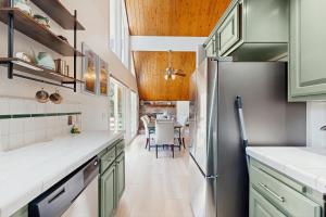 a kitchen with green cabinets and a dining room at The Fairway Chalet in Lake Arrowhead