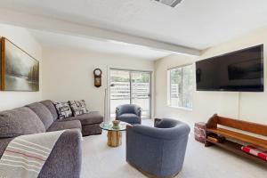 a living room with a couch and a tv at The Fairway Chalet in Lake Arrowhead +21 photos