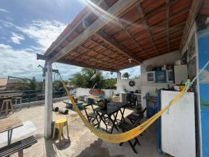a porch with a hammock and a kitchen on a roof at Trip Hostel e Pousada in Jericoacoara