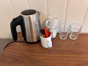 a coffee maker and two glasses on a table at Halden Motell in Halden