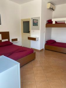 a bedroom with two beds with red sheets at Vila Hana in Dhërmi