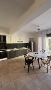 a kitchen with a table and chairs in a room at aganta apartments in Olympiada